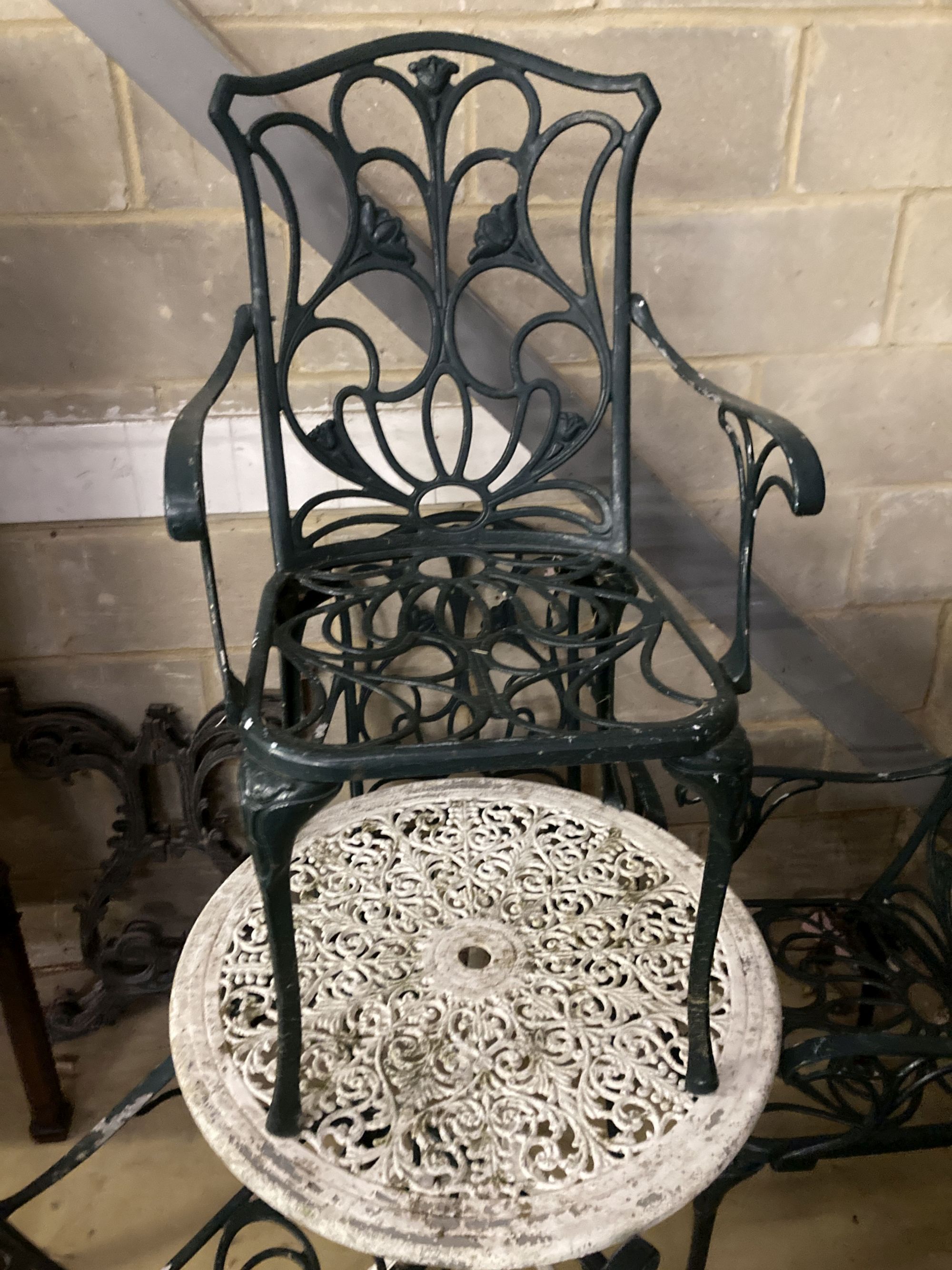 A Victorian style painted circular aluminium garden table, 68cm diameter together with a set of four painted aluminium garden elbow cha